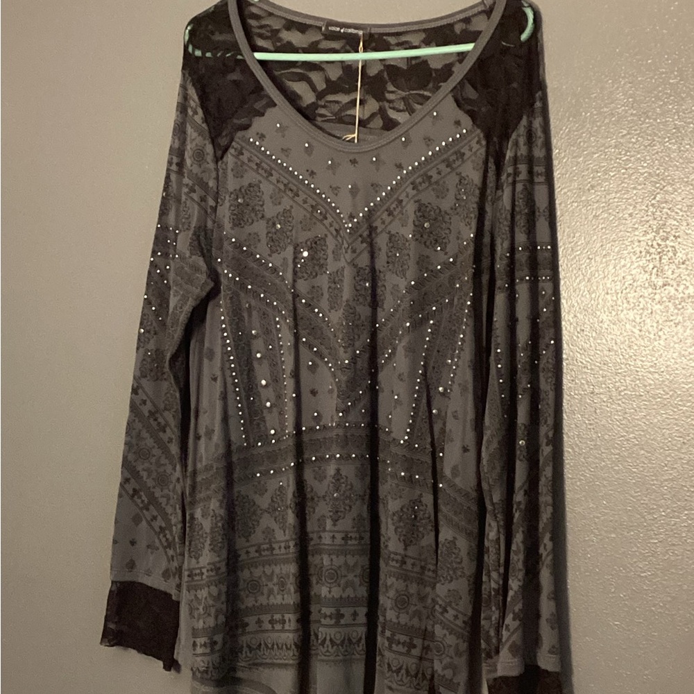 Women’s gray and black long sleeve shirt with lace at the cuffs.